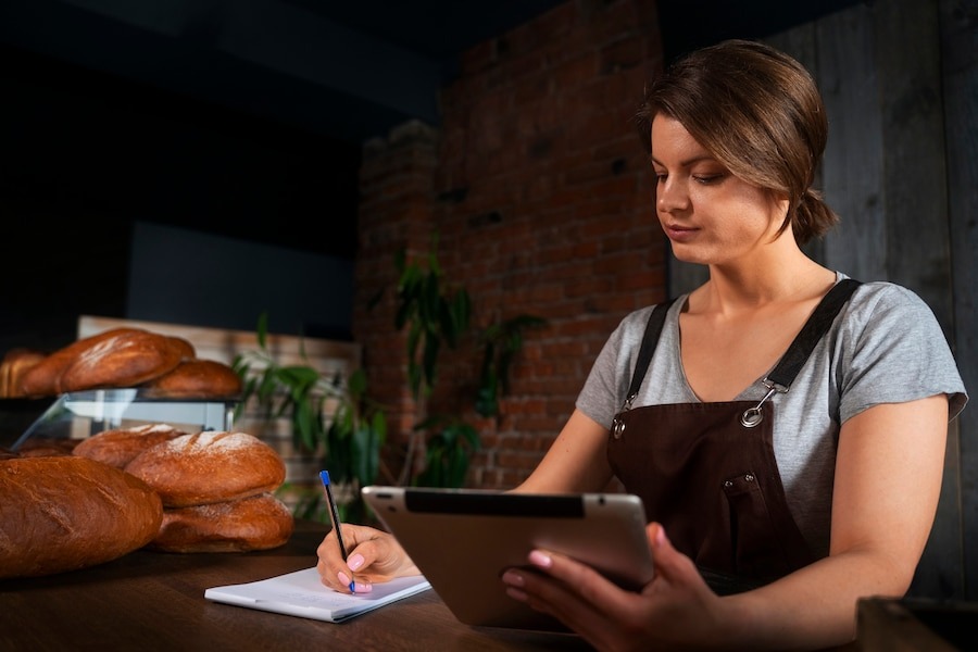 female baker shop with tablet ta